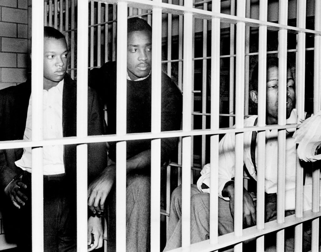 John Lewis, right, a student at American Baptist Theological seminary, talks to reporters at Nashville city jail March 25, 1960, after his arrest at the downtown Moon-McGrath drugstore lunch counter. Also arrested were O.D. Hunt, left, and Dennis Gregory Foote, students at Tennessee A&I State University.