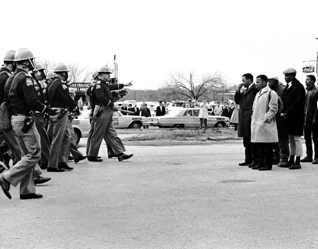 Two-minute Warning. John Lewis, Hosea Williams and the other Foot Soldiers are confronted by Alabama State Police on the Edmund Pettus Bridge on Bloody Sunday.